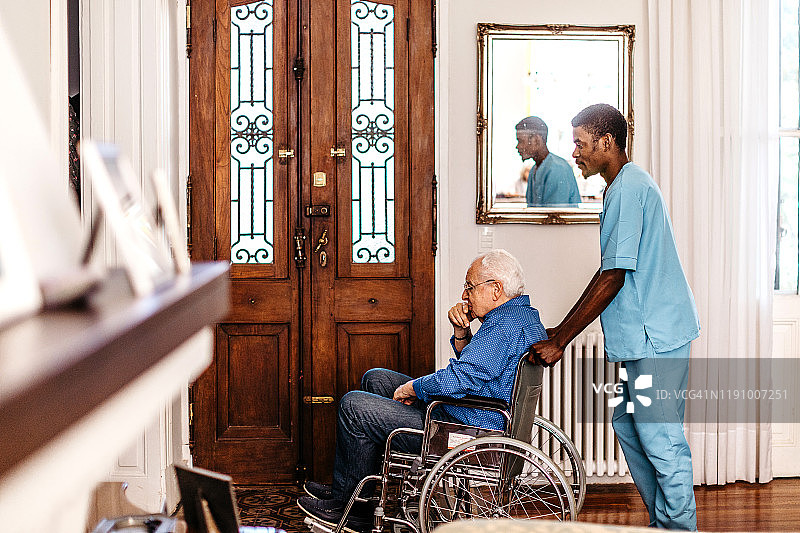男护士用轮椅推着老人图片素材