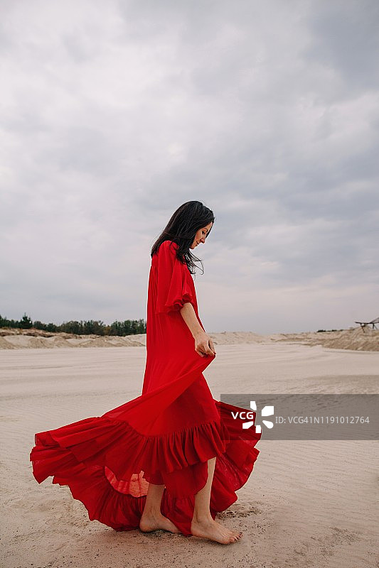在俄罗斯沙漠里，穿着红色连衣裙的女人图片素材