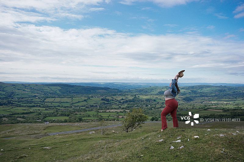 美丽的女人在空中举起双臂，黑色山脉，波伊斯，斯诺多尼亚，威尔士，英国图片素材