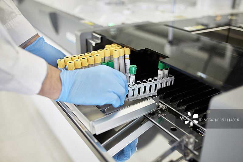 病理学家在试管架中处理血液样本图片素材