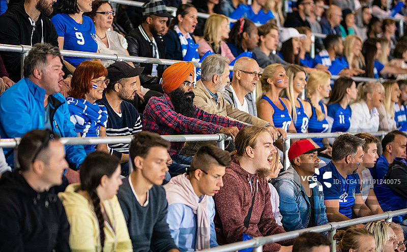 挥舞蓝色充气棒的欢呼粉丝图片素材