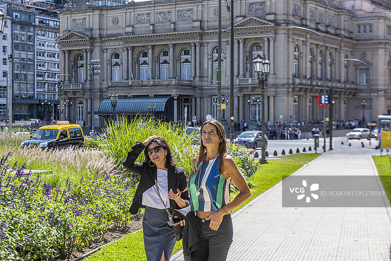 在阿根廷布宜诺斯艾利斯公园里交谈散步的两位年轻女子图片素材