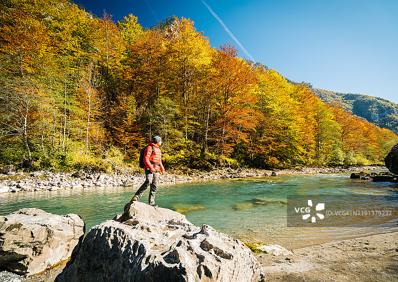 徒步旅行者在秋季河流附近放松身心图片素材