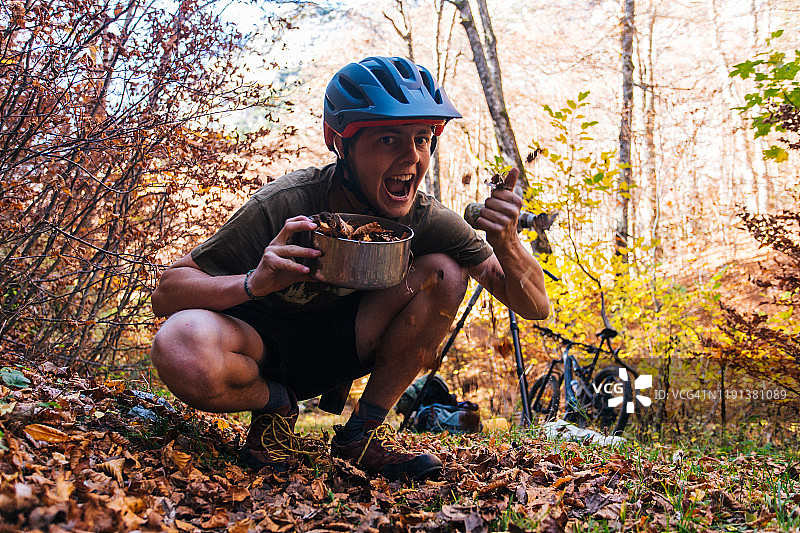 山地自行车手在森林里手捧树叶微笑图片素材