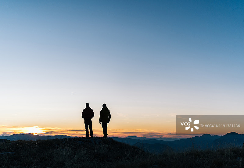 徒步者在日出时分于山谷上方休息图片素材