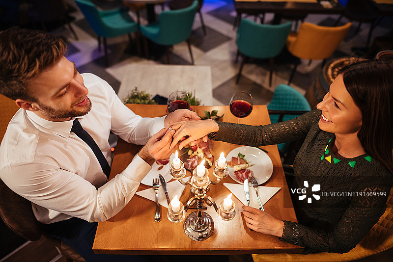 男人将订婚戒指戴在女友的手指上图片素材