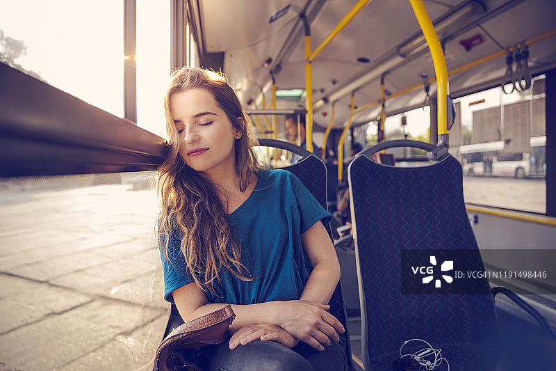 女人在公交车上通勤时睡觉图片素材