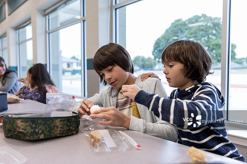 午餐时间，弟弟打扰在学校的哥哥图片素材
