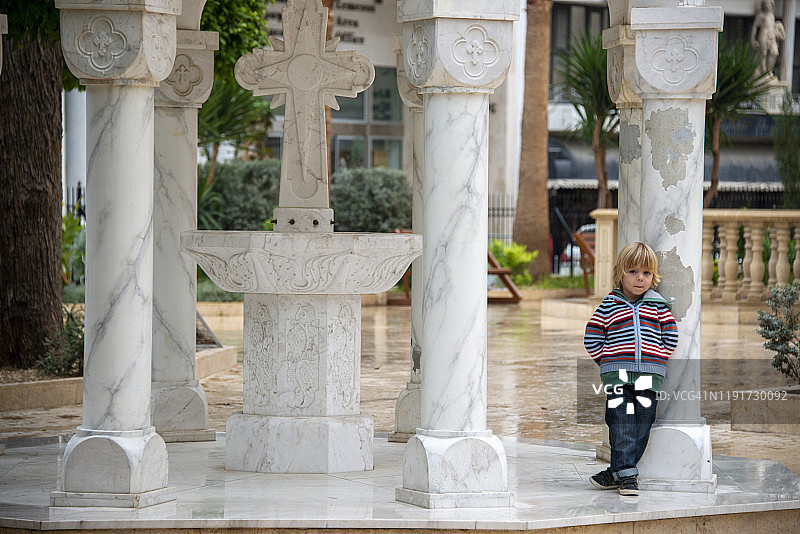 小男孩在塞浦路斯利马索尔的阿依纳帕教堂庭院休息图片素材