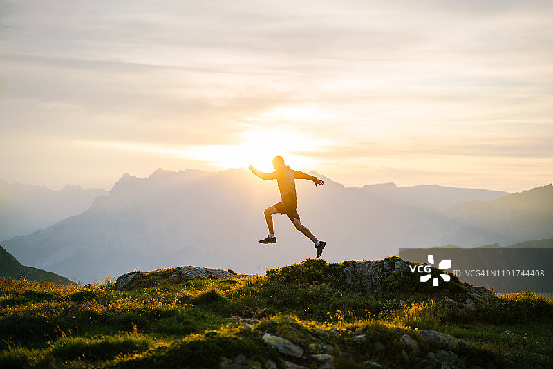 日出时在山脊上奔跑的年轻人图片素材