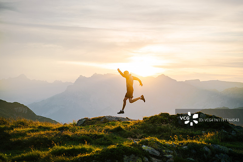 日出时在山脊上奔跑的年轻人图片素材