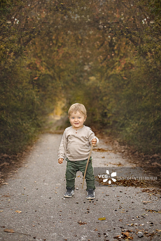 一个一岁大的男孩玩树枝图片素材