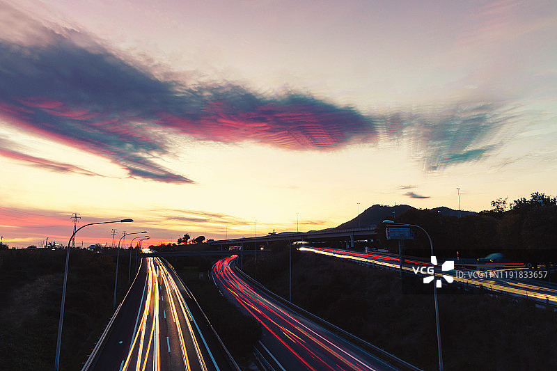 创意延时摄影：高速公路上行驶的汽车，长曝光光轨，日落美景图片素材