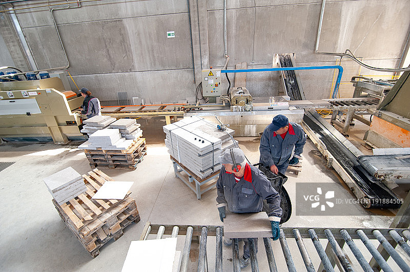 男人们在瓷砖制造厂生产线末端工作图片素材