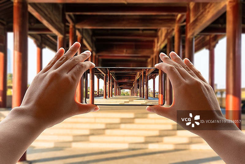 用智能手机拍摄通道内的木制亭阁图片素材