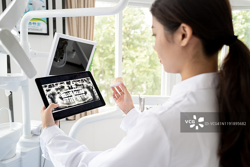 女牙医用数位板看牙齿X光片图片素材