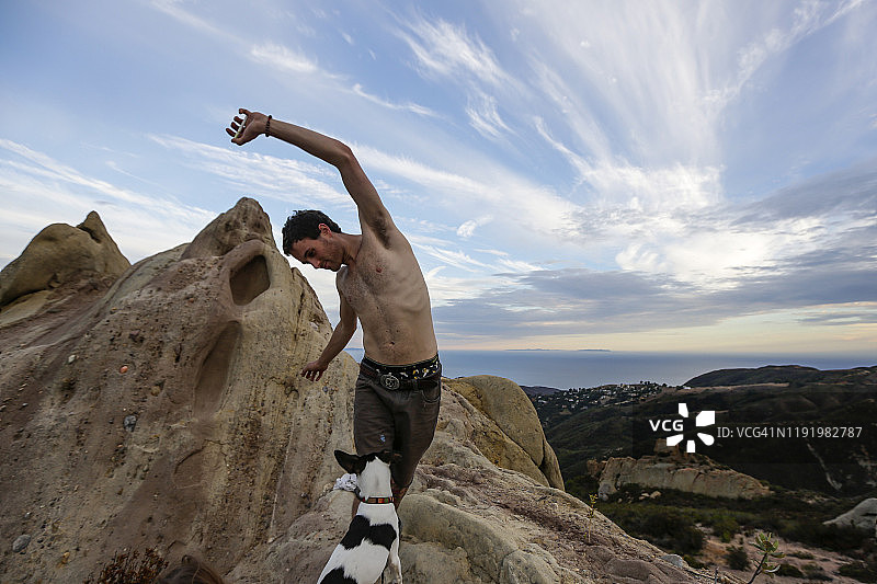 在悬崖边跑步，背景是壮丽天空的男人图片素材