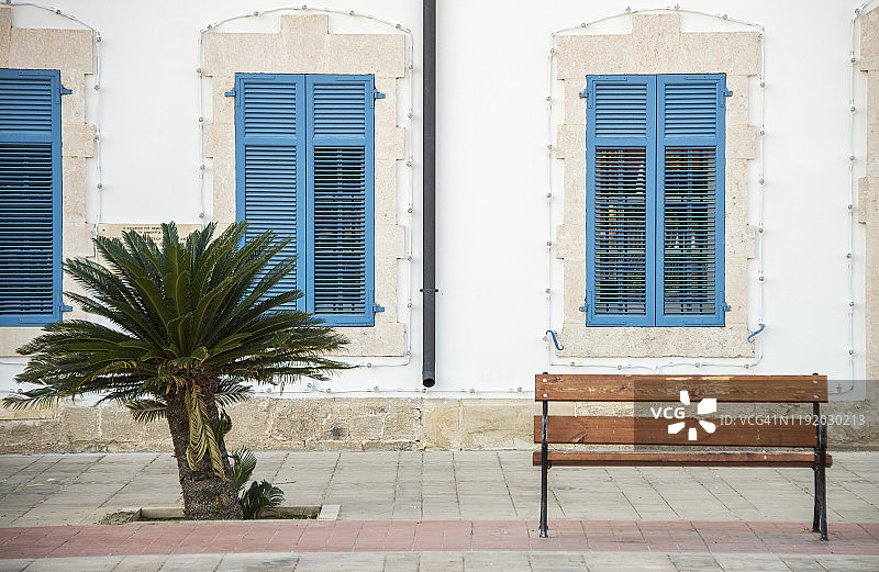 拉纳卡欧洲广场棕榈树旁的简约长椅，塞浦路斯图片素材