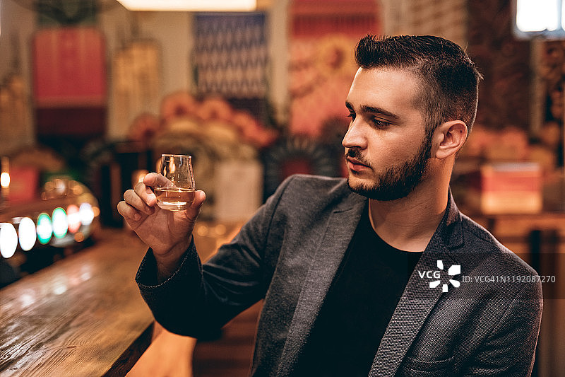 手持一杯威士忌的英俊男人图片素材