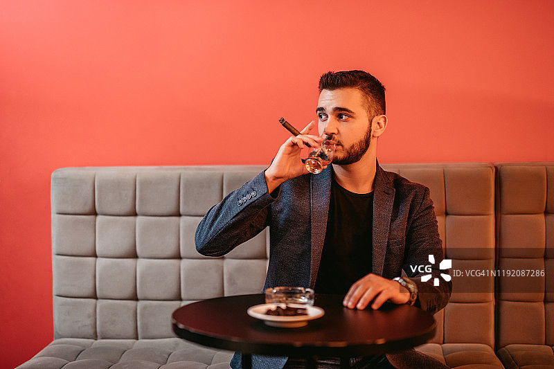 手持一杯威士忌的英俊男人图片素材