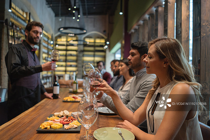 朋友们在酒吧品酒，有侍酒师图片素材