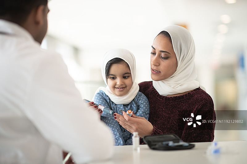 医生讲解如何为母女注射胰岛素图片素材