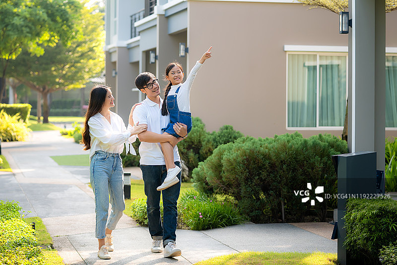 亚洲家庭在村庄新房前散步图片素材