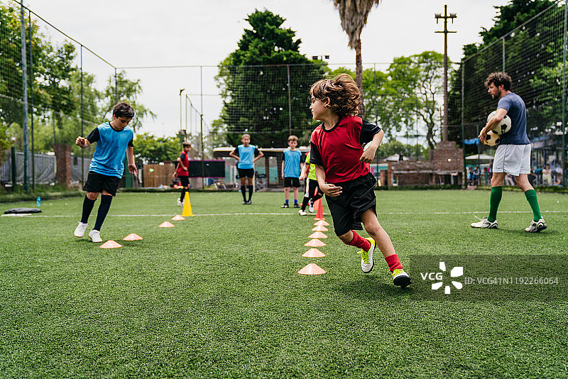 男孩们在球场上练习足球图片素材