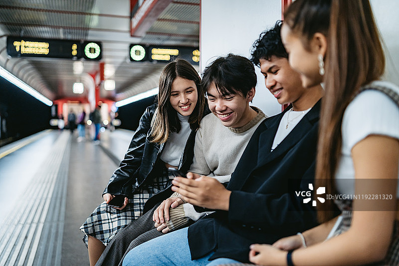 在地铁里使用手机的亚洲青少年图片素材