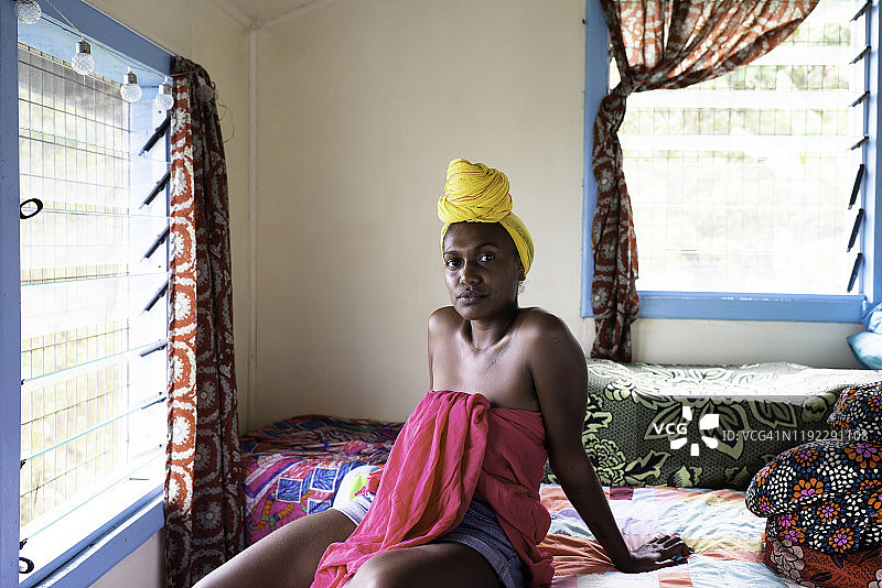 卧室里身穿亮色服装的年轻女子图片素材