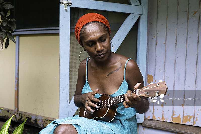 在家弹尤克里里的年轻女子图片素材