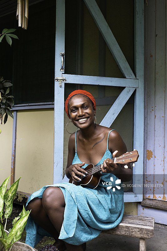 在家弹尤克里里的年轻女子图片素材