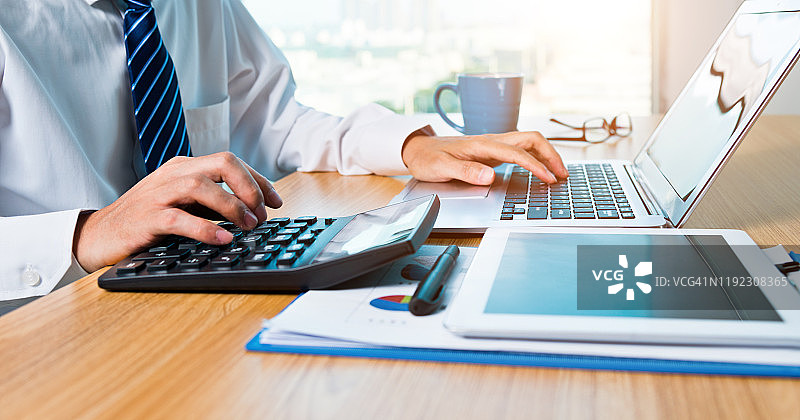 商人在办公室使用数位板和笔记本电脑工作图片素材