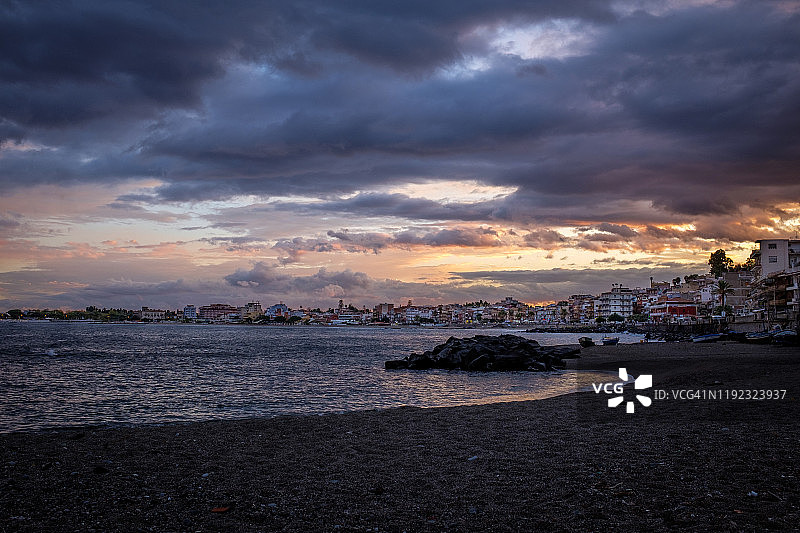 贾尔迪尼-纳克索斯的日落，左边是海洋，右边是城市图片素材