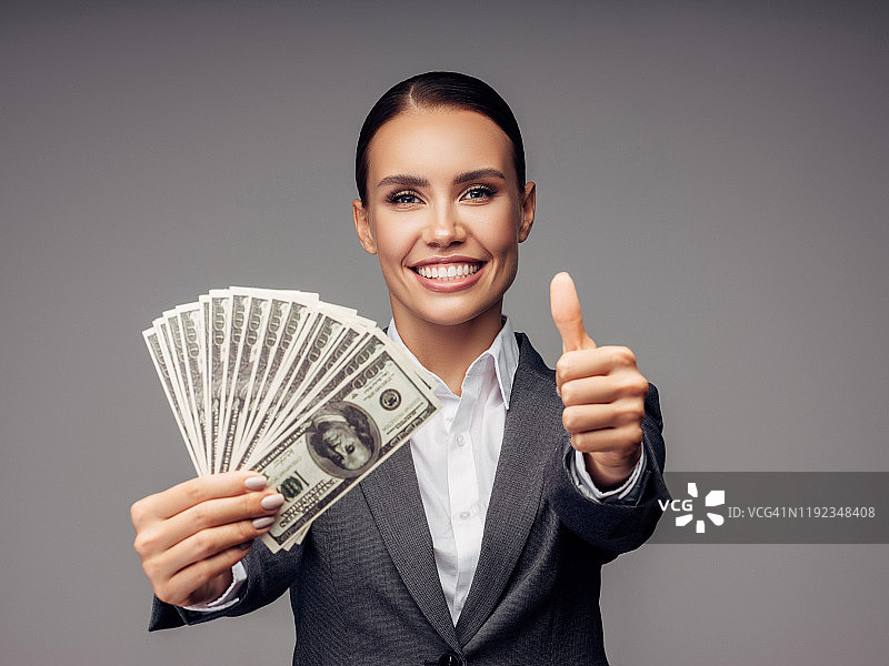 手持一堆钞票的年轻女商人图片素材