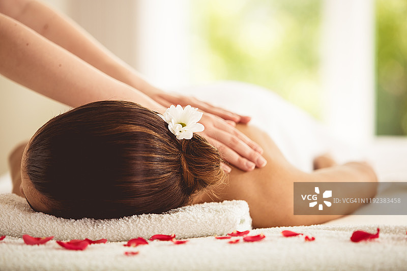 女子在水疗中心享受肩部按摩图片素材