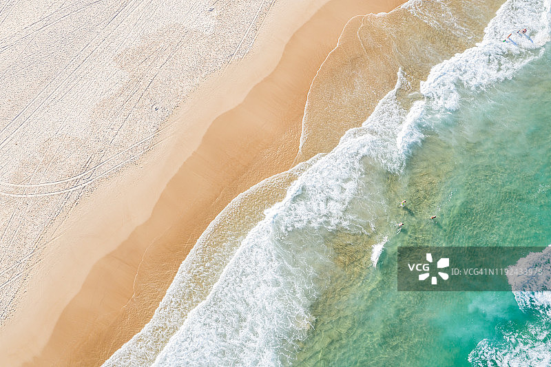 海浪和沙滩上游泳的人们的航拍图片素材