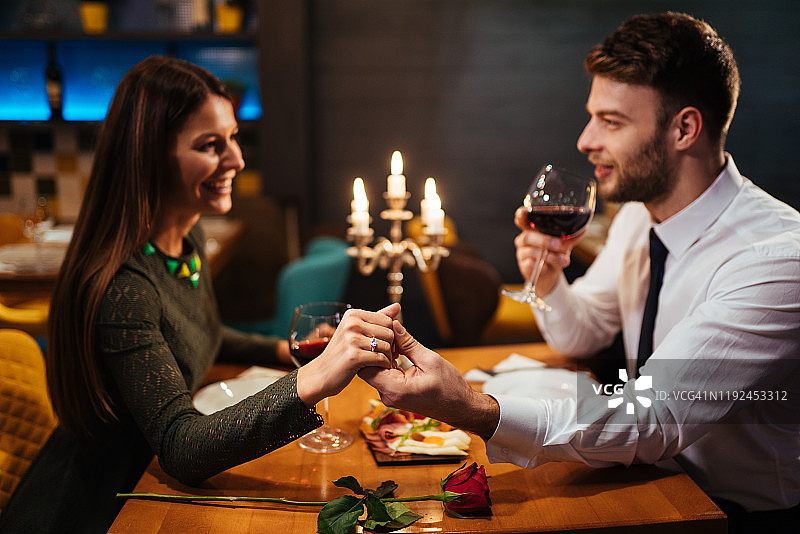 情侣在餐厅浪漫晚餐时手牵手图片素材