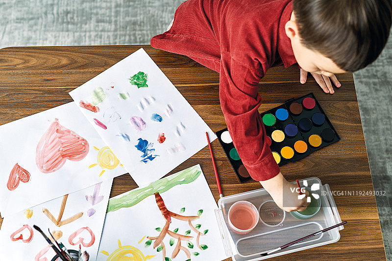 在家用水彩画画的2-3岁儿童图片素材