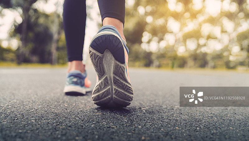 特写：跑步女性的脚和运动鞋，展现健康的生活方式图片素材