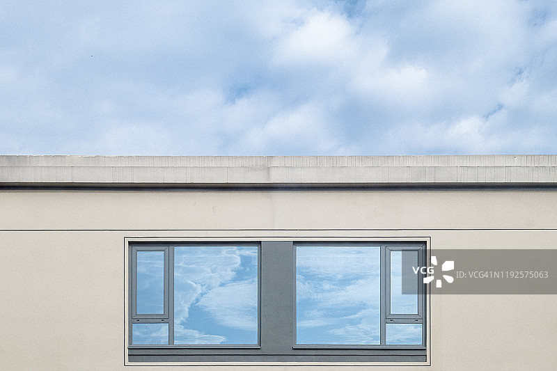 蓝天白云下的建筑与玻璃上的倒影图片素材