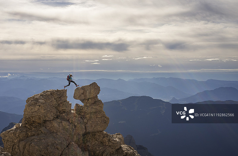 登山者在岩石间跳跃图片素材