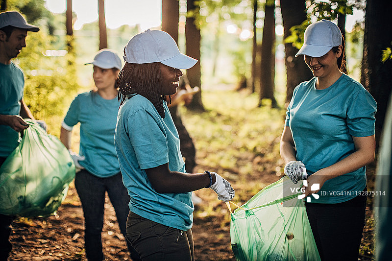 志愿者在公园里用垃圾袋清理垃圾图片素材