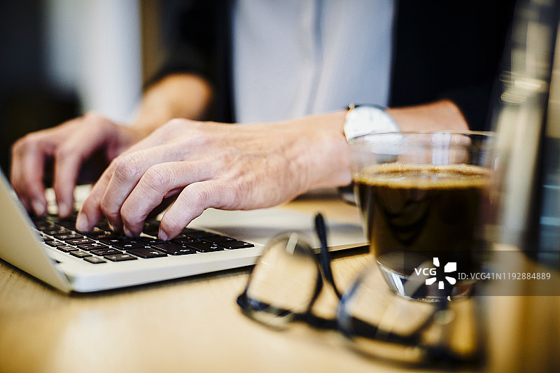 中年律师在办公室的办公桌前使用笔记本电脑图片素材