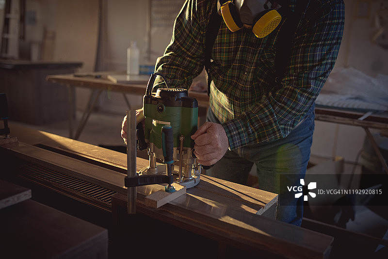 使用电动工具的资深木匠图片素材