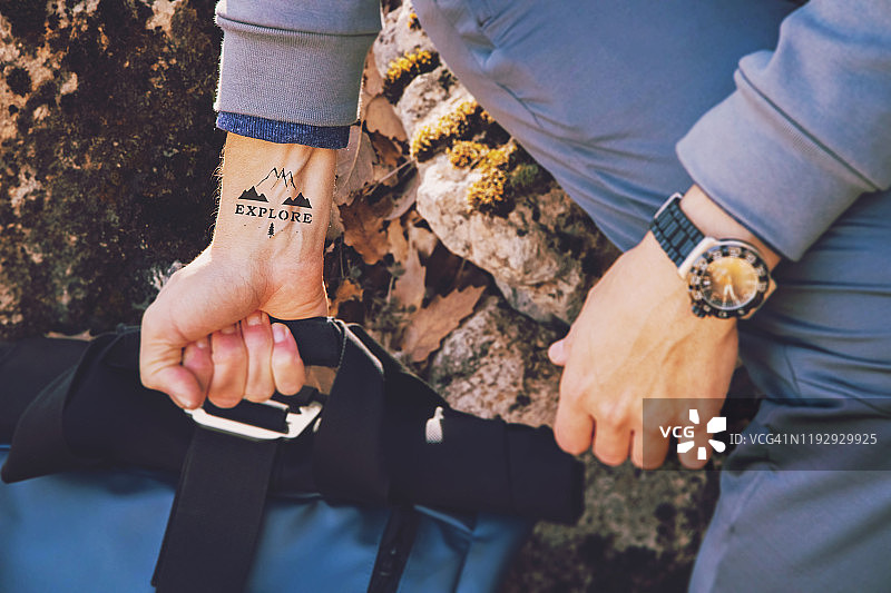 在自然中，手腕上带有探索纹身的背包男人图片素材
