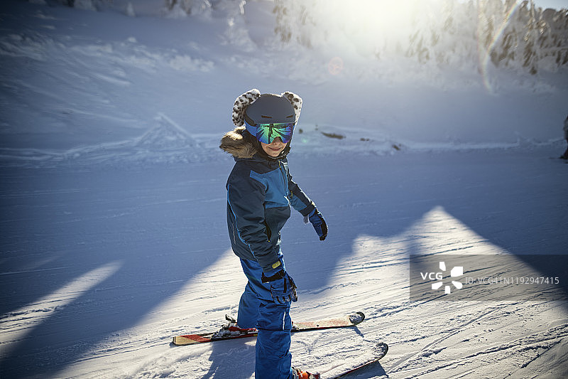小男孩在美丽的冬日滑雪图片素材