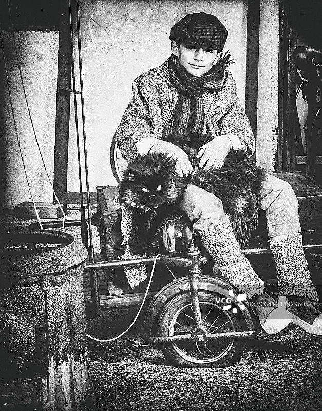 穿着复古服装抱着猫的男孩图片素材