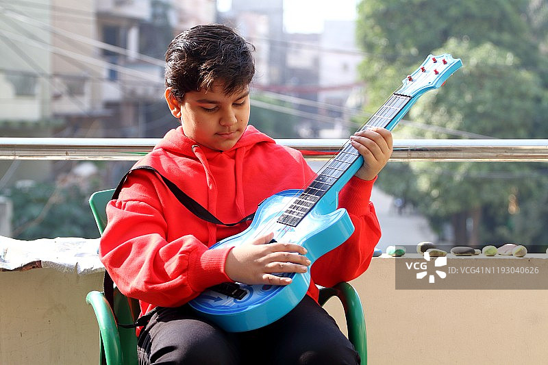 小男孩户外弹吉他图片素材