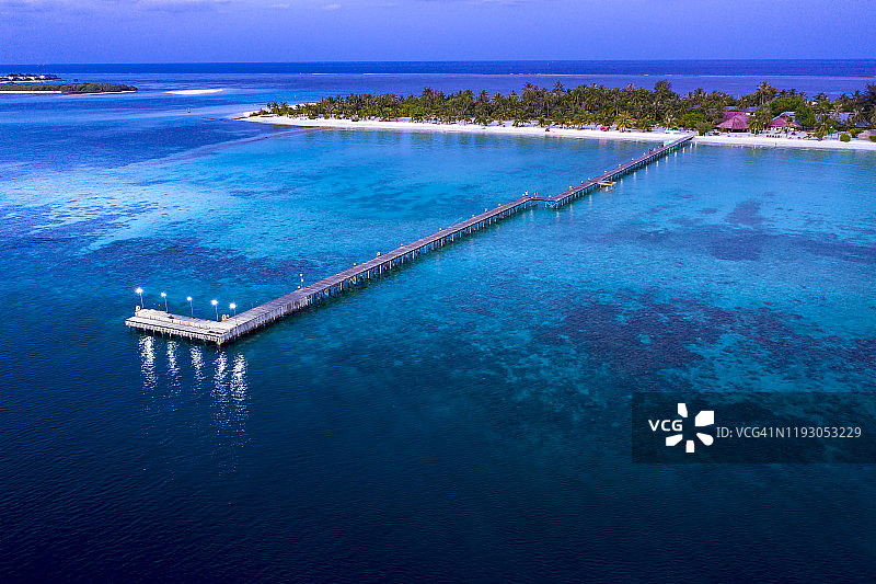 马尔代夫博杜菲诺卢岛，南马累环礁的沿海旅游度假村码头在黄昏时的航拍图图片素材